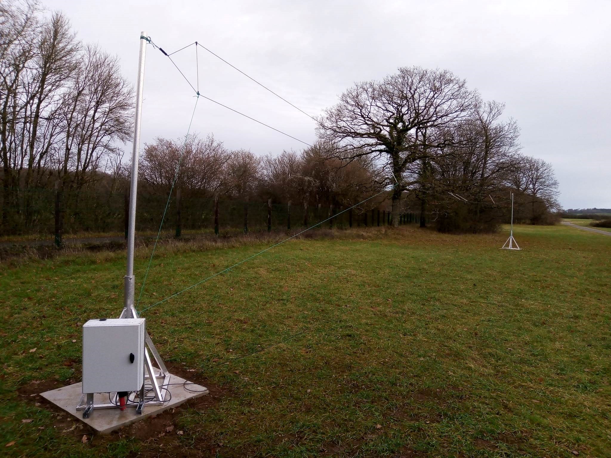 De zendantenne in Dourbes (links, 25 meter lang), en de ontvangst antenne op het dak van het KMI in Ukkel (rechts, 1 meter doorsnede)